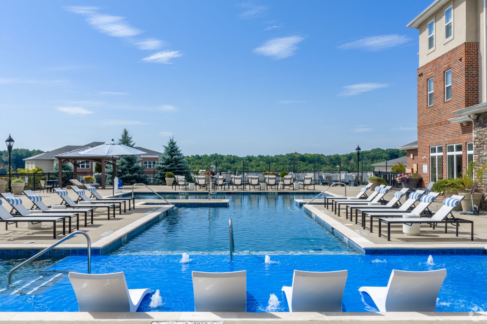 The-View_001 Resort-style swimming pool surrounded by lounge chairs, tables, umbrellas, and apartment buildings