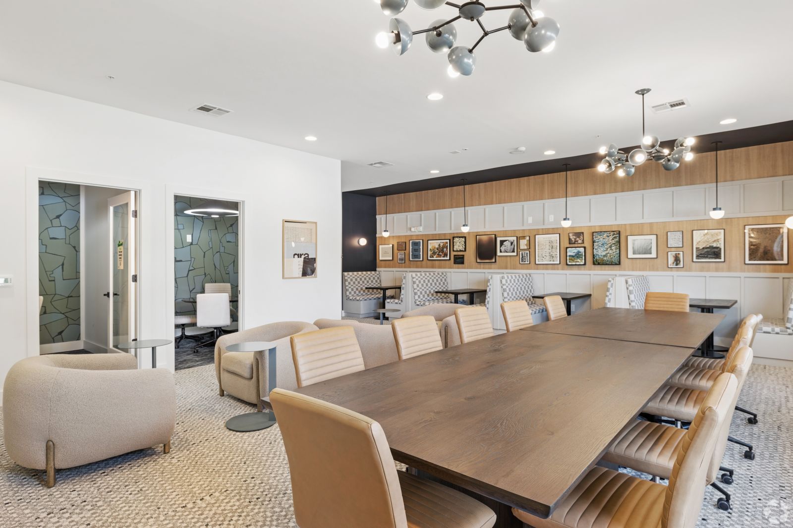 Resident conference room with a long table, upholstered chairs, lounge seating, and framed artwork