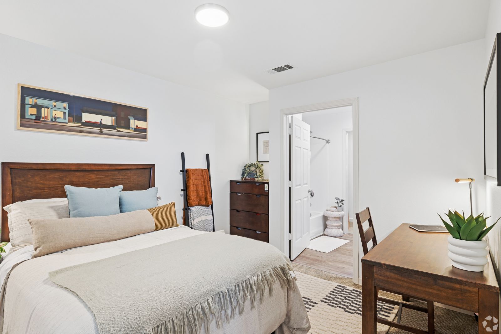 Bedroom with a dark wood bed, white bedding, nightstands, a dresser, and an open doorway